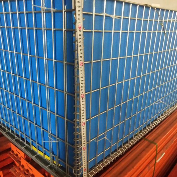 Galvanized storage cage in use at warehouse facility